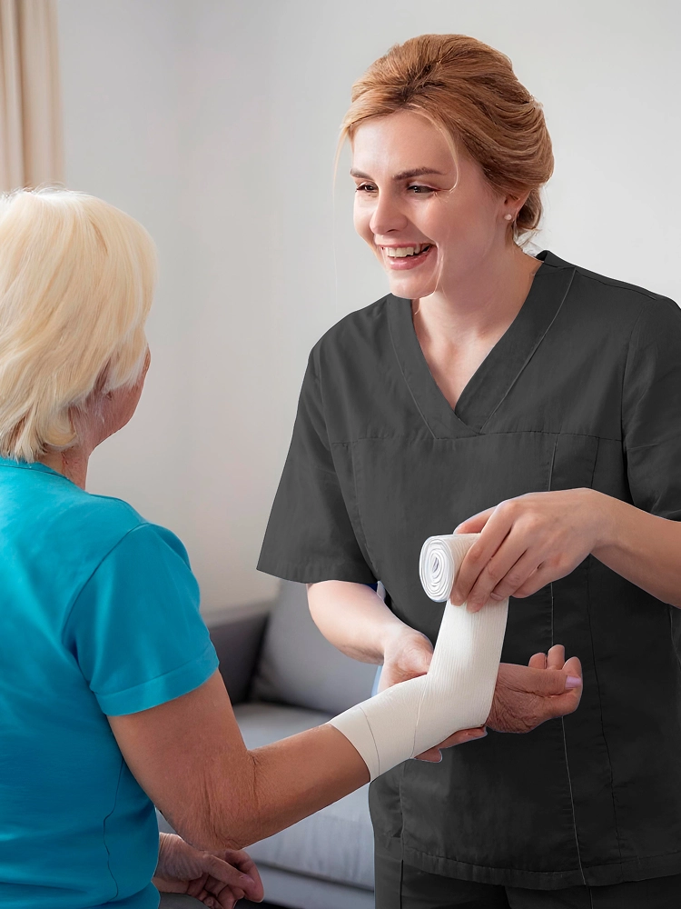 Home health professional wrapping injured arm with medical bandage
