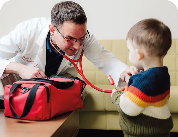 Life Medical doctor performing at-home urgent care examination on a toddler with a stethoscope.