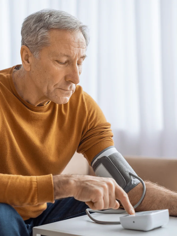 Man checking blood pressure with remote monitoring device